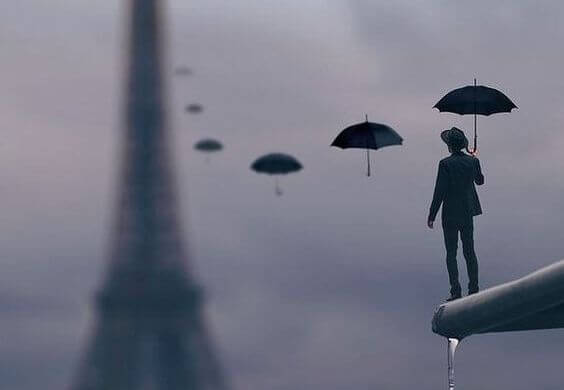Elinde şemsiyesi ile Eyfel Kulesine bakan adam