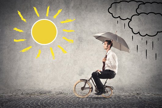 yağmurdan güneşe bisikletle giden adam