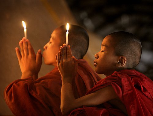 Ellerinde mum ile dua eden Budist çocuklar