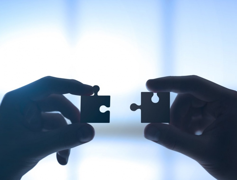 puzzle parçaları tutan eller