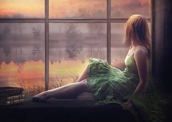 kadın pencereden gün batımı izliyor