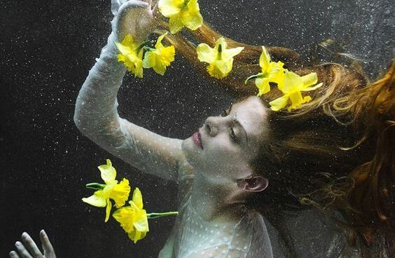 su altında kadın ve sarı çiçekler
