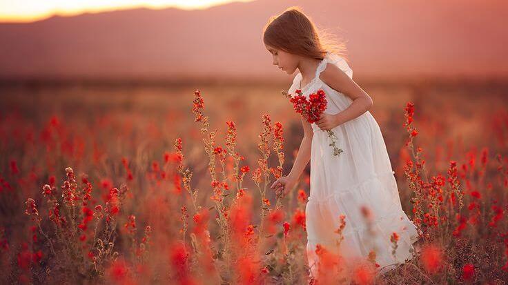 kırmızı çiçekler toplayan beyaz elbiseli kız