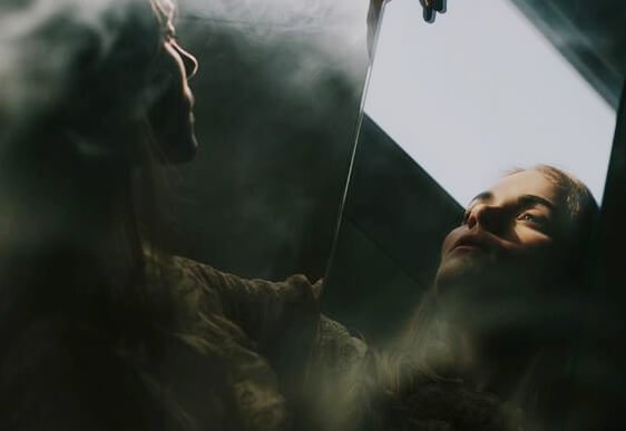 aynada yansımasına bakan kadın