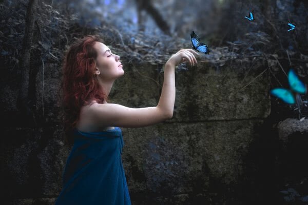 eline mavi kelebek konan kızıl saçlı kadın