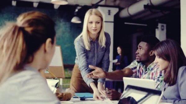 ofis ortamında çalışanlar ve kadın ekip lideri