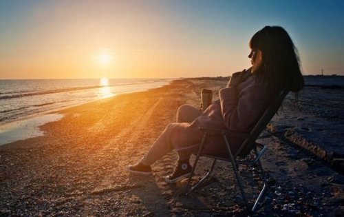 kumsalda oturan kadın kahve ve gün batımı