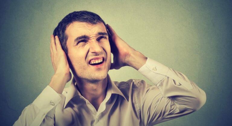 ses yüzünden kulaklarını kapatan adam