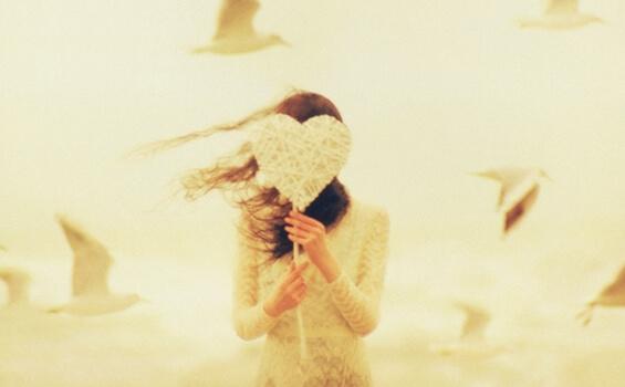 yüzünü kalp arkasına gizlemiş kadın