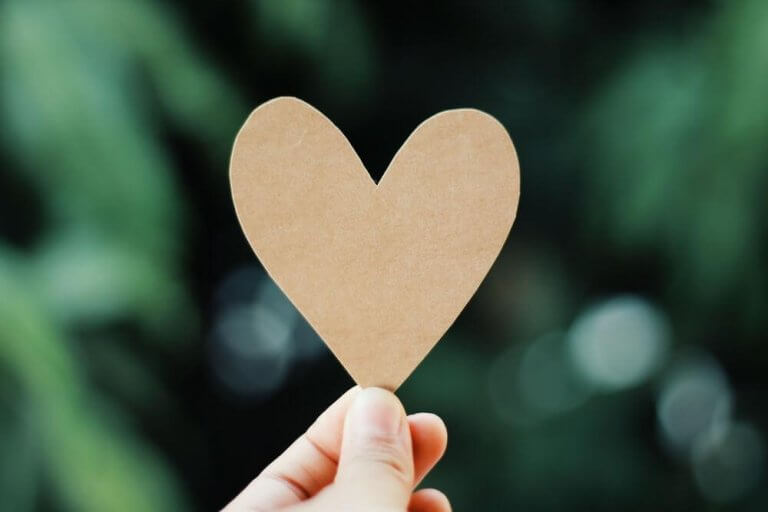 elinde kağıttan kalp tutan parmak