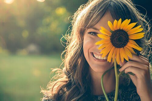 çiçek tutan ve gülümseyen kadın