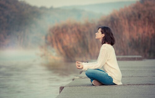 Göl kenarında meditasyon yapan kadın