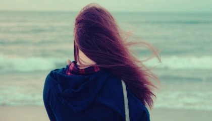 rüzgarda deniz kenarında duran kadın