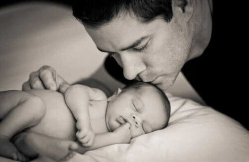 uyuyan bebeğini öpen baba