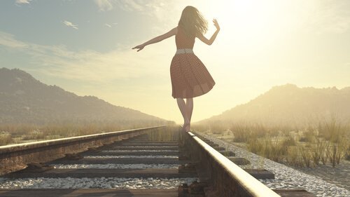 tren rayları üzerinde yürüyen kadın