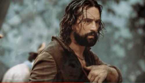 Elini göğsüne koymuş bir adamın fotoğrafı.