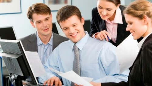 iş yerinde kağıda bakan mutlu insanlar