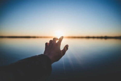 Güneşe doğru uzanan bir elin fotoğrafı.