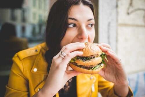 Restoranda hamburger yiyen kadın