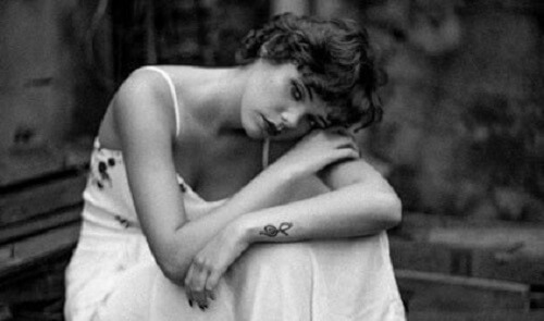 Beyaz elbiseli, üzgün görünen bir kadın.