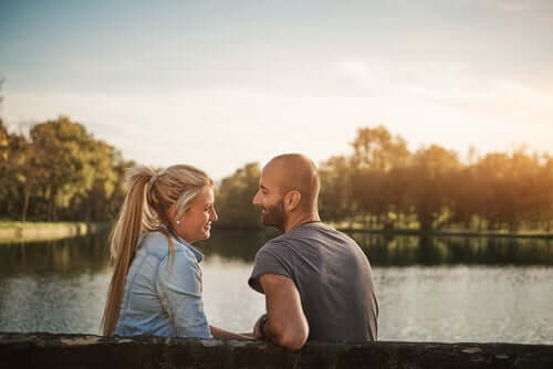 Bir gölün önünde konuşan bir adam ve bir kadın.