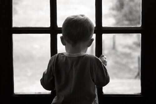 Pencereden bakan bir çocuğun siyah beyaz bir resmi.
