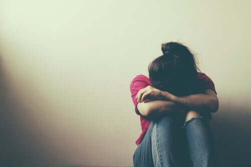 Duvarın önünde dizine kapanmış ağlayan kadın