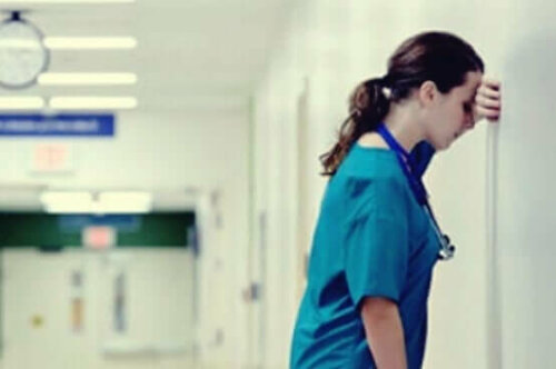 bitkinlikten duvara dayanan hemşire