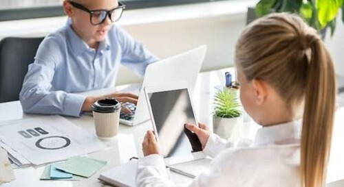 Elektronik aletler kullanarak ders çalışan iki çocuk.