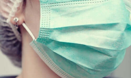 cerrahi maske takmış olan doktor