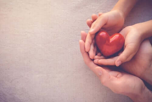 Bir yetişkin ve bir çocuğun ellerinin içerisindeki bir kalp.