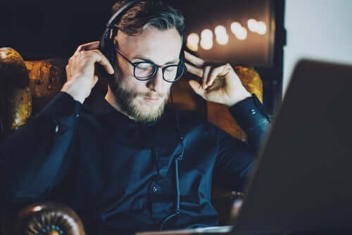 dizüstü bilgisayarında müzik dinleyen adam