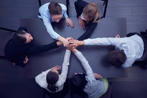 İş birliğini temsil edecek şekilde ellerini bir araya koymuş çalışanlar.