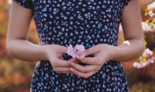 Elinde çiçek tutan bir kadın.