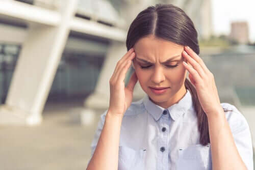Stresli durumlar dolayısıyla baş ağrısı çeken bir kadın.