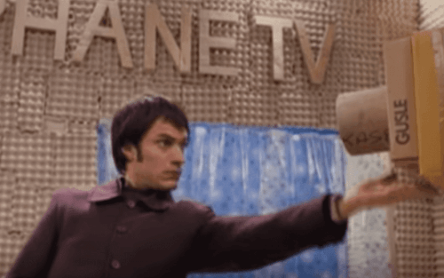 Bir adam karton kamerayı tutuyor.