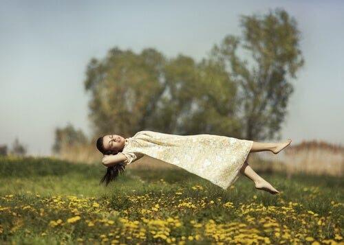 Bir tarlanın üstünde havada süzülen bir kadın.