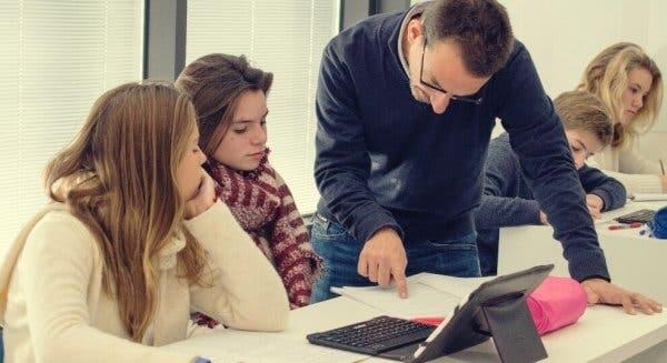 Öğrencilerine bir şeyler anlatan bir öğretmen.