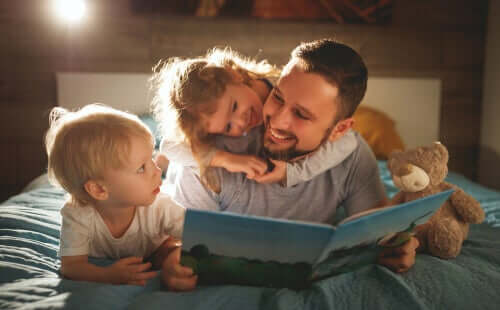 Çocuklarının okuduğunu anlaması için onlarla kitap okuyan bir baba.
