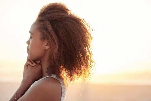 güneş ışığında huzurlu bir şekilde duran kıvırcık saçlı kadın