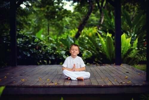 Kendisine bir barış köşesi bulmuş, meditasyon yapan bir çocuk.