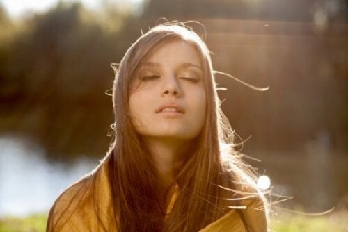 Gözleri kapalı bir şekilde düşünen bir kadın.