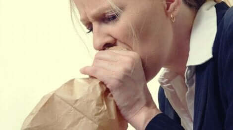 hiperventilasyon ile anksiyete: kağıt torbaya nefes alan kadın