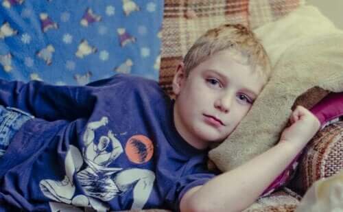 Kanepede yatan üzgün bir çocuk.