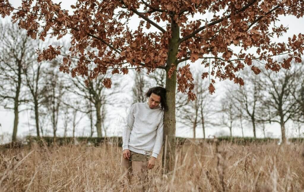 ağaca yaslanmış bir çocuk