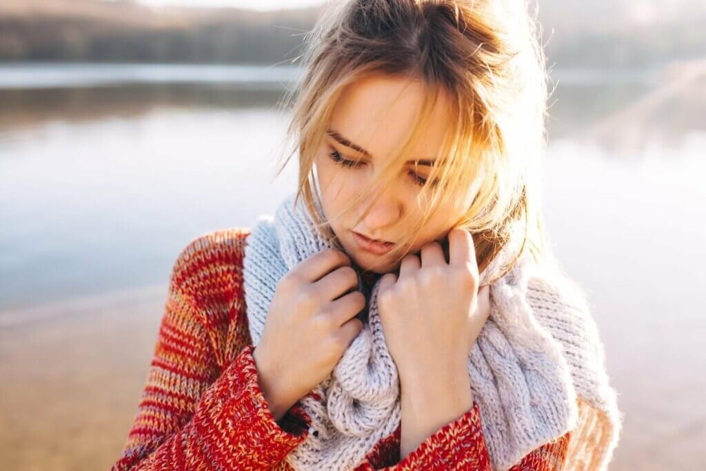 Göl kenarında yürüyüş yapan düşünceli kadın