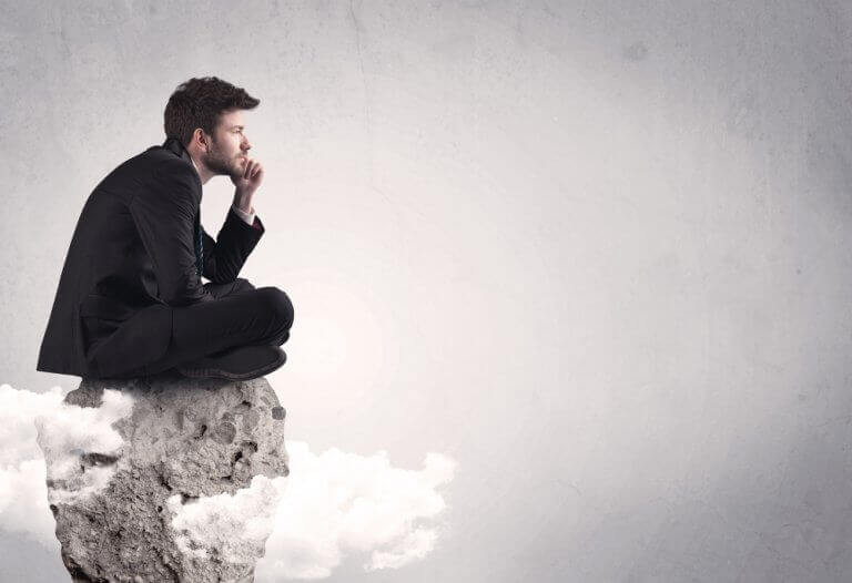 kayaya çömelmiş düşünen adam