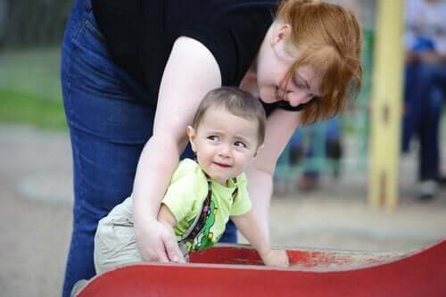 parkta bebeğiyle oynayan anne