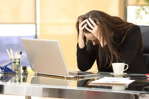 iş yerinde stresten başı ağrıyan kadın