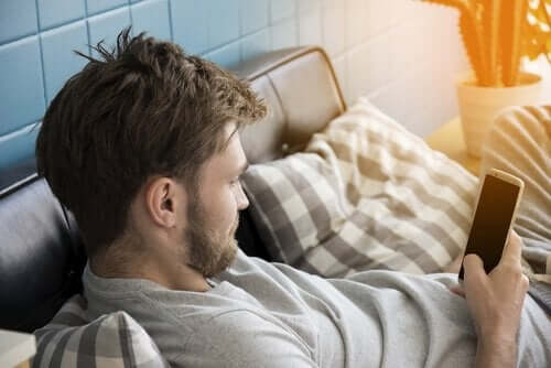 koltukta oturmuş telefonunda vakit geçiren adam